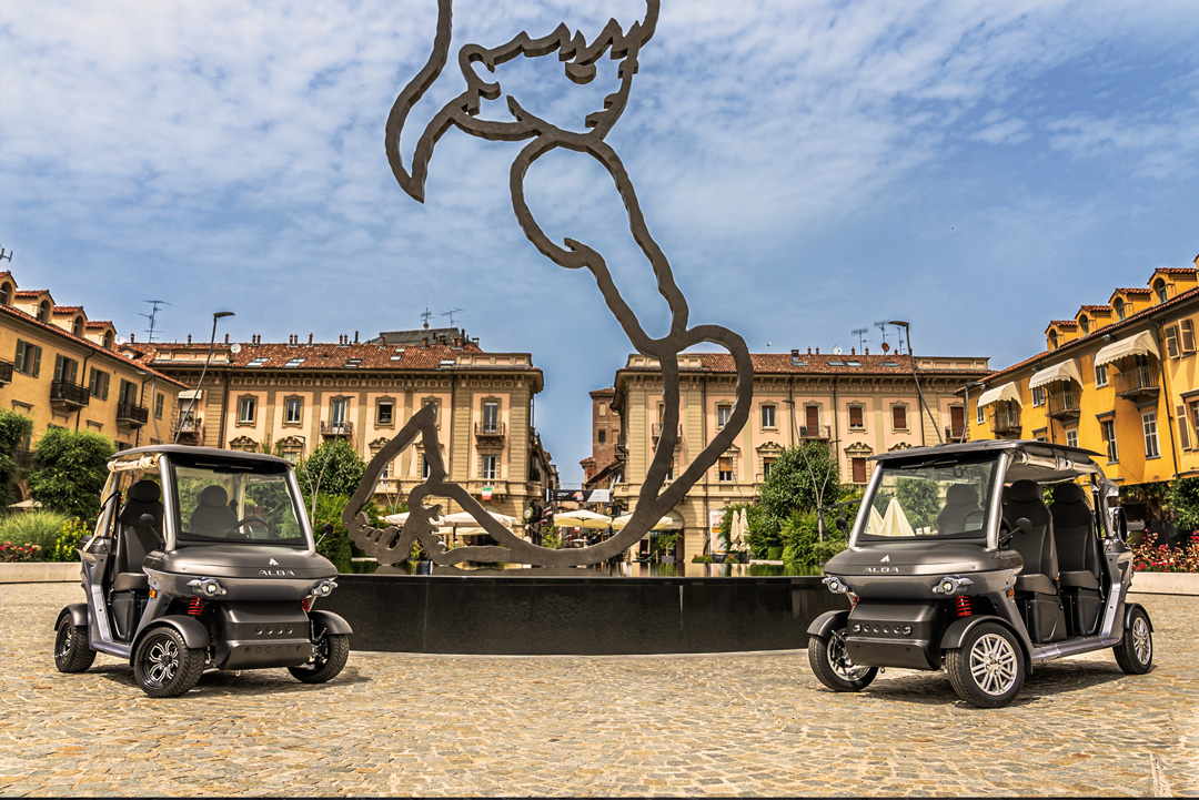 Cart elettrici 2 e 4 posti Alba 2SC e Alba 4SC omologati per uso stradale, esposte in una piazza di Alba in attesa di di turisti per visite guidate tramite NCC con autorizzazione ZTL